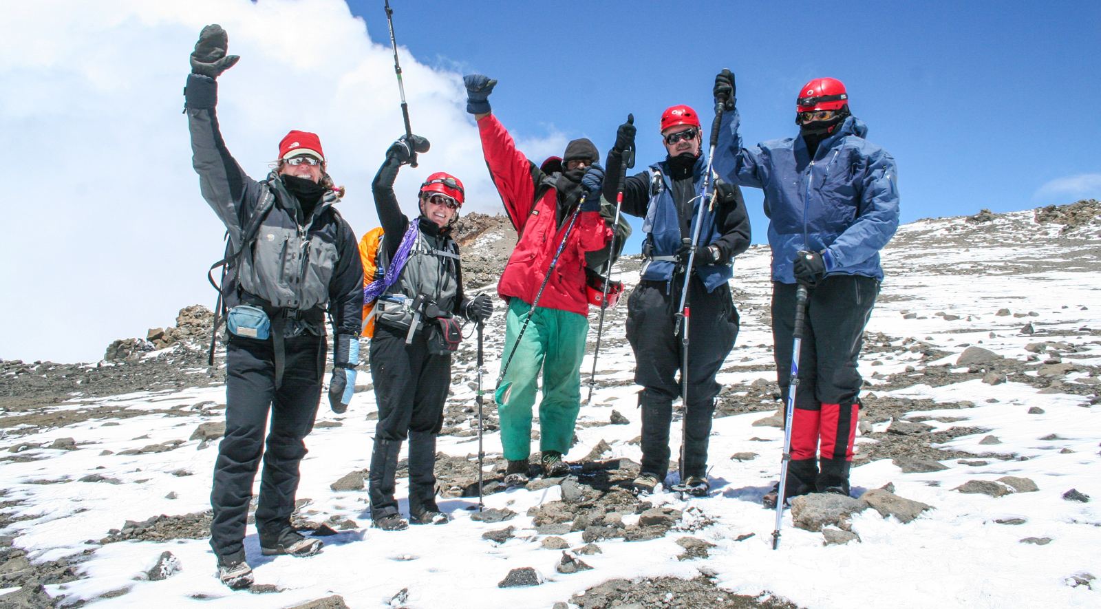 Climbers cheering in the snow near the summit of Kilimanjaro