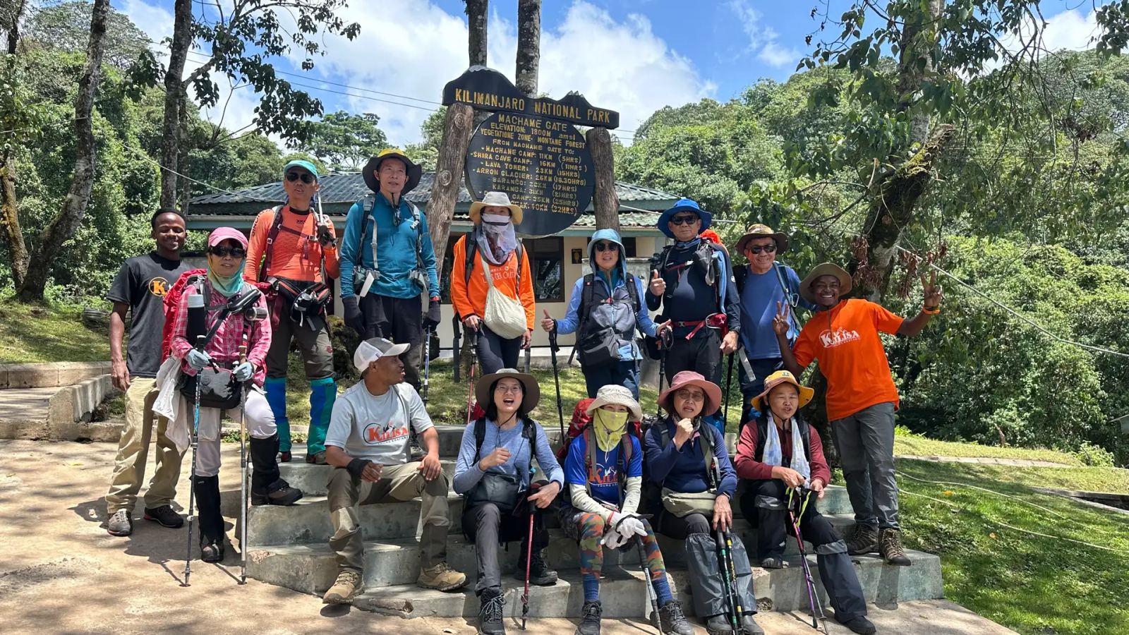 Large trekking group with Kilisa Tours guides at the Machame Gate sign, Kilimanjaro National Park