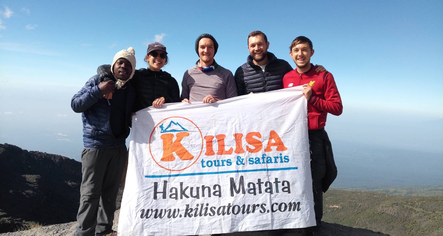 Climbers holding a Kilisa Tours banner on Kilimanjaro